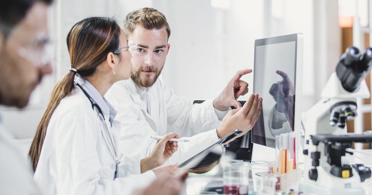 Lab workers looking at a monitor