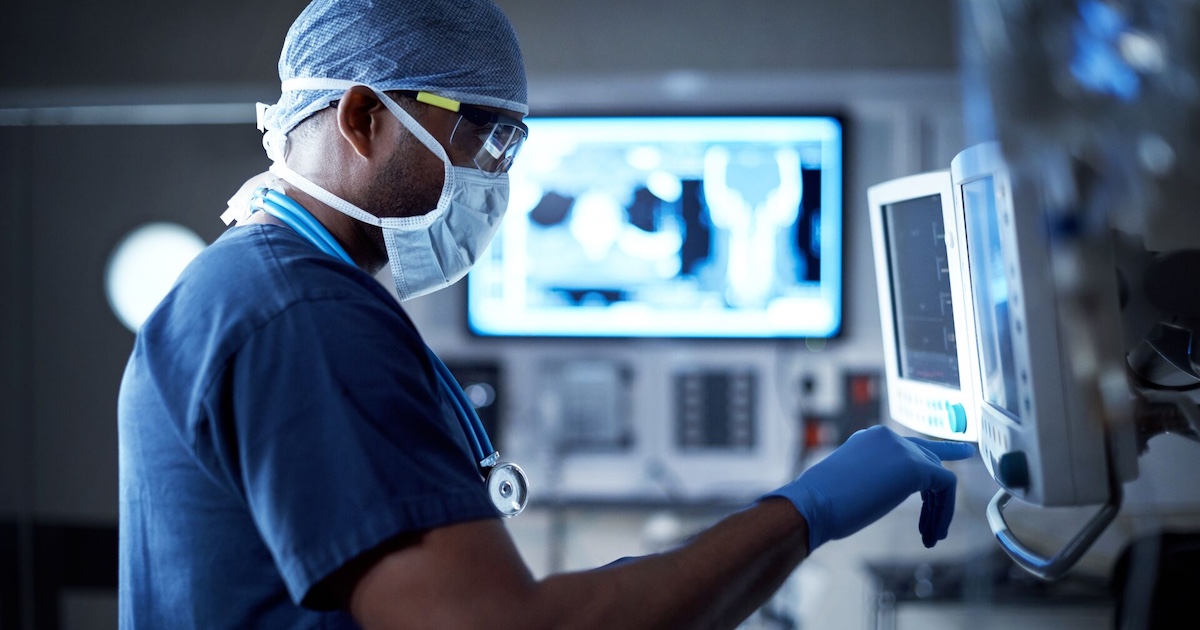 Healthcare worker in mask looking at display