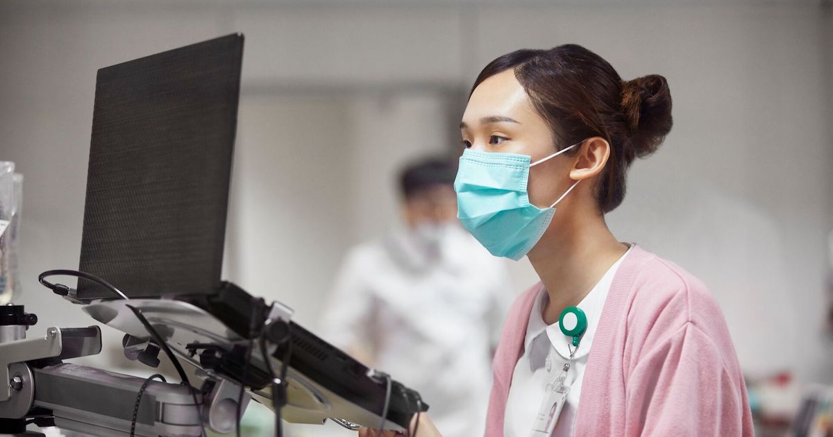 A nurse writing a medical record on a laptop