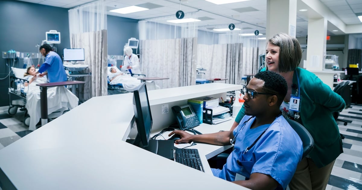 Nurses using a desktop computer in their station