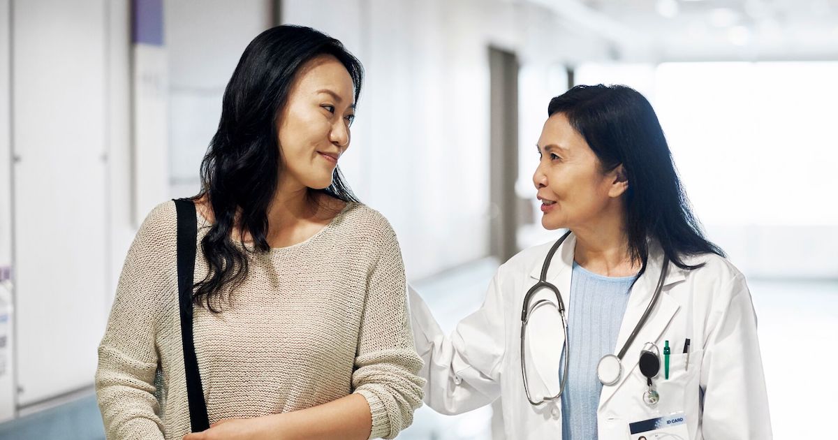A doctor walking with a patient in a hospital corridor