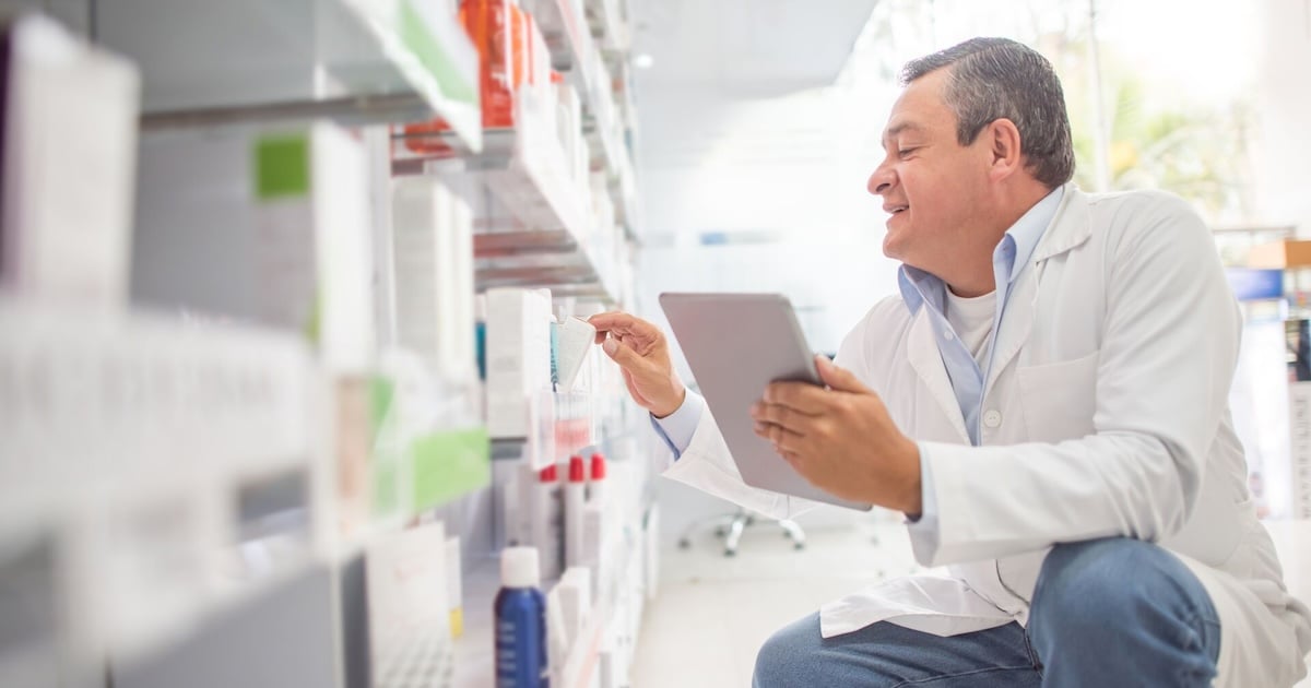 A pharmacist using a digital tablet to do an inventory