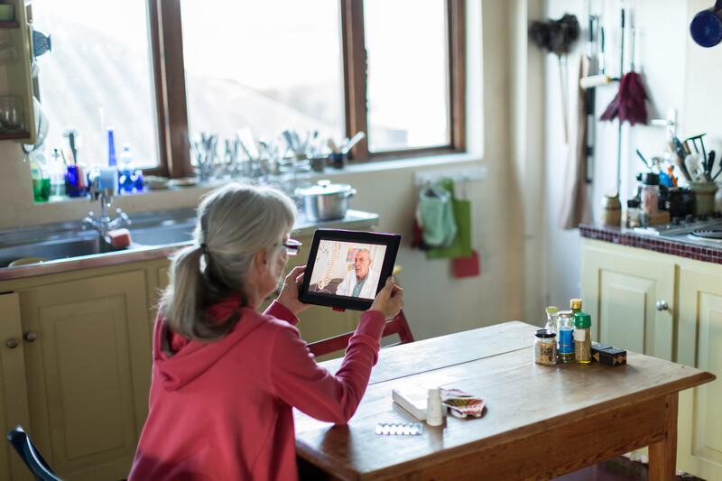 A person having a consultation with a medical professional on a tablet.