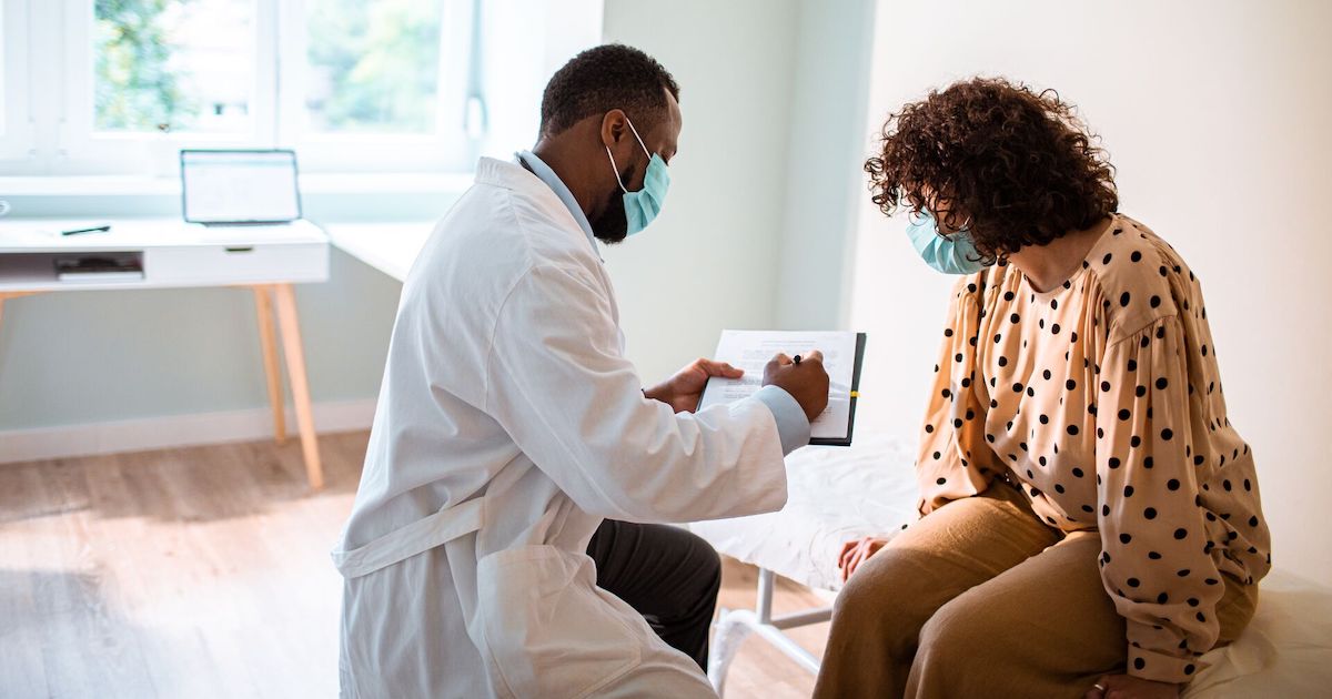 Doctor showing clipboard to patient