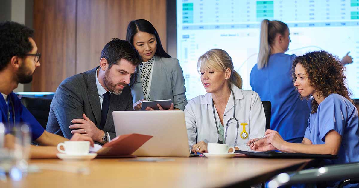Healthcare workers meeting around a laptop