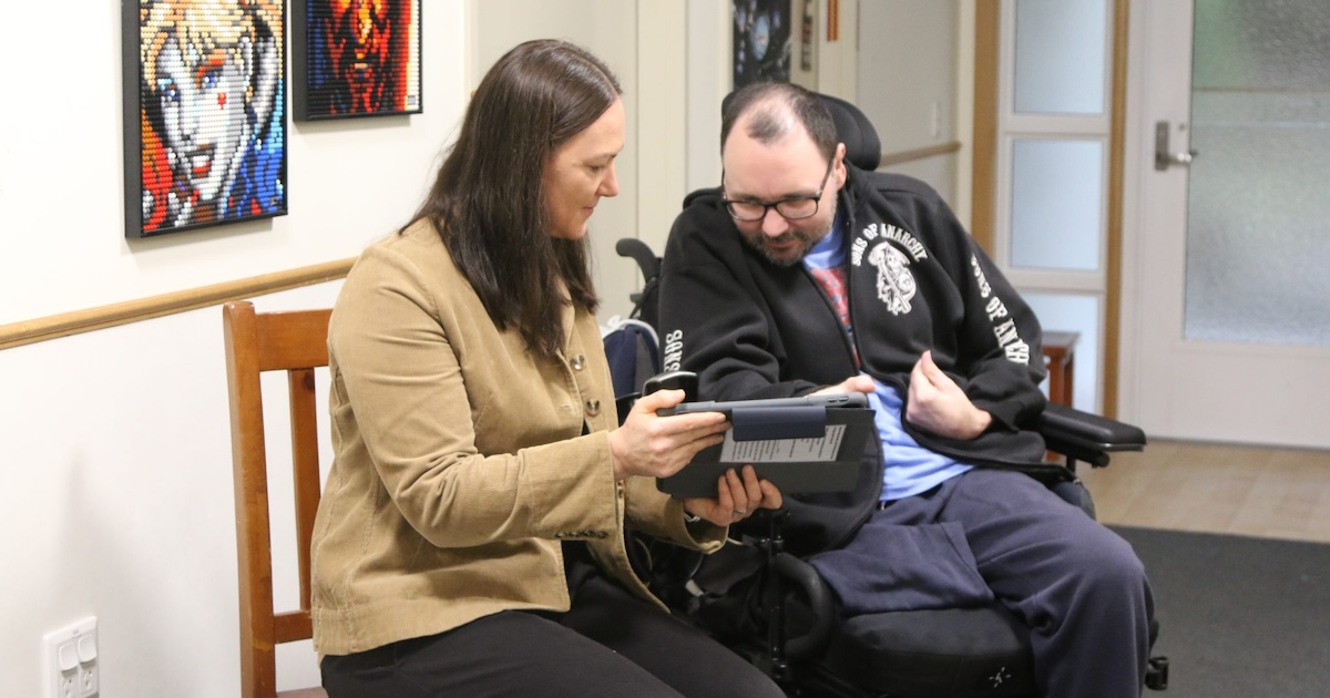 A Peninsula Health staff assisting a patient in inputting their care needs and preferences