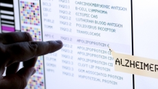 A finger points to a line of data on a computer screen