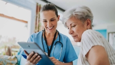 Healthcare worker showing tablet to patient