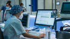 Person in PPE at computer