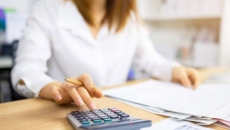 Woman at a desk works on a calculator