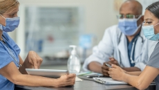Healthcare worker showing tablet to others