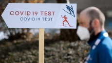 A person stands in front of a COVID-19 test sign