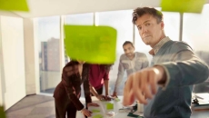 Co-workers reviewing ideas on glass wall_EMEA HITN_Getty-Shannon Fagan