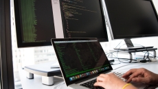 Developer typing on multiple screens