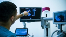 doctor points at an image on one screen at a multi-screen medical station