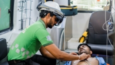 An emergency medical technician using the Microsoft HoloLens to locate areas for ECG Probe Placement in a patient