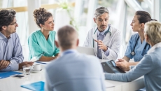 Doctors and payers sit around a table discussing claims data, prior authorizations and more.