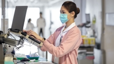 A nurse using a laptop to write a medical report