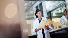 A doctor reviewing a paper patient record