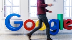 A person walking by the Google logo