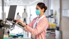Healthcare worker in mask entering data