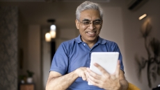 Person smiles as they use an app on a tablet.