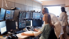 Healthcare workers looking at group of monitors