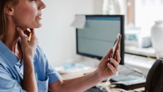 Person holds neck while holding up phone