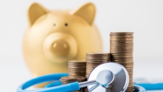 Piggy bank with stack of coins and stethoscope