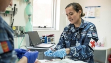 A military medical staff inserting tubes into a patient