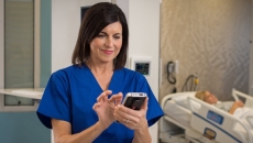 A nurse using a device under Ascom Intelligence