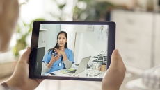 Person consults with person wearing stethoscope via tablet