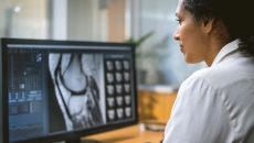 Healthcare worker looking at medical image on computer