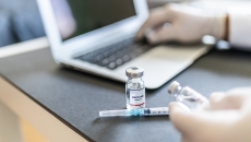 Vaccine vials by a laptop computer