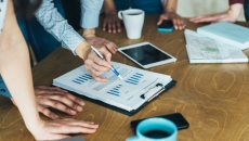 Business meeting with tablet and graph on table