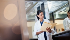 Doctor reviews information in a folder