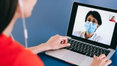 A patient speaks to a doctor on a computer