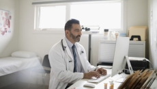 A person wearing a stethoscope on a computer