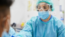 A doctor in protective gear gives a patient a COVD test