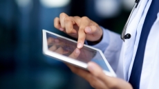A clinician using an EHR on a tablet