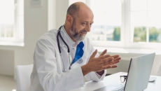 A doctor speaks with a patient via videochat