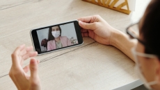 A doctor on a phone screen with a patient