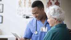 Doctor helping patient with tablet