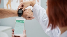 Healthcare worker syncing smartwatch with smartphone app