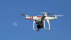 A drone in the sky against a moon