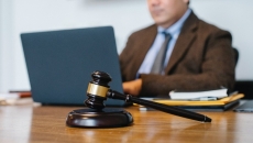 A gavel with a lawyer in the background