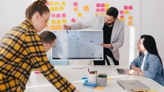 A person presenting to others via screen in a conference room