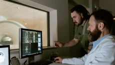 Two people look at diagnostic images on a screen
