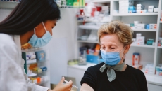 Person in mask recieving vaccine at a pharmacy