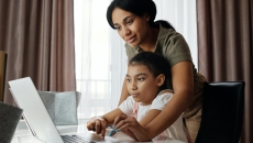 A parent and child look at a computer